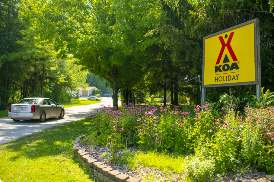 Photo of a KOA Holiday entry way with landscaped flowers and plants